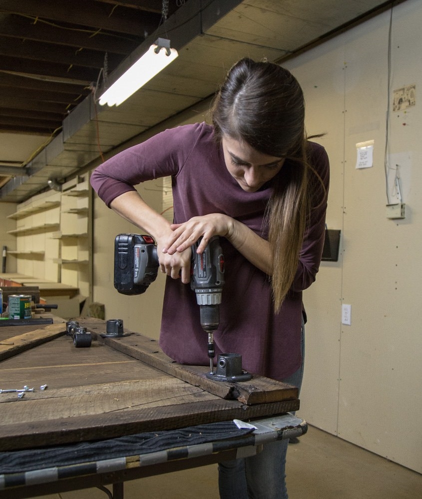 woman attaching table legs to desk top