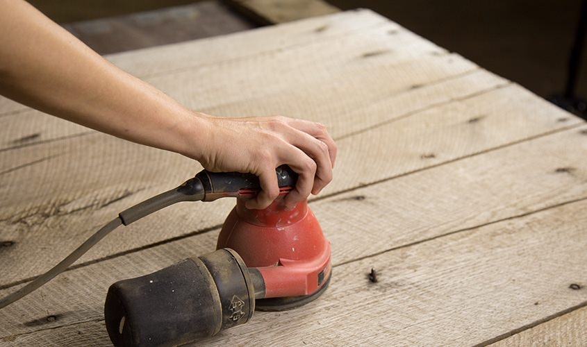 female hand holding power sander