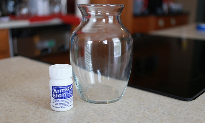 a clear glass vase sitting next to a bottle of glass etching compound